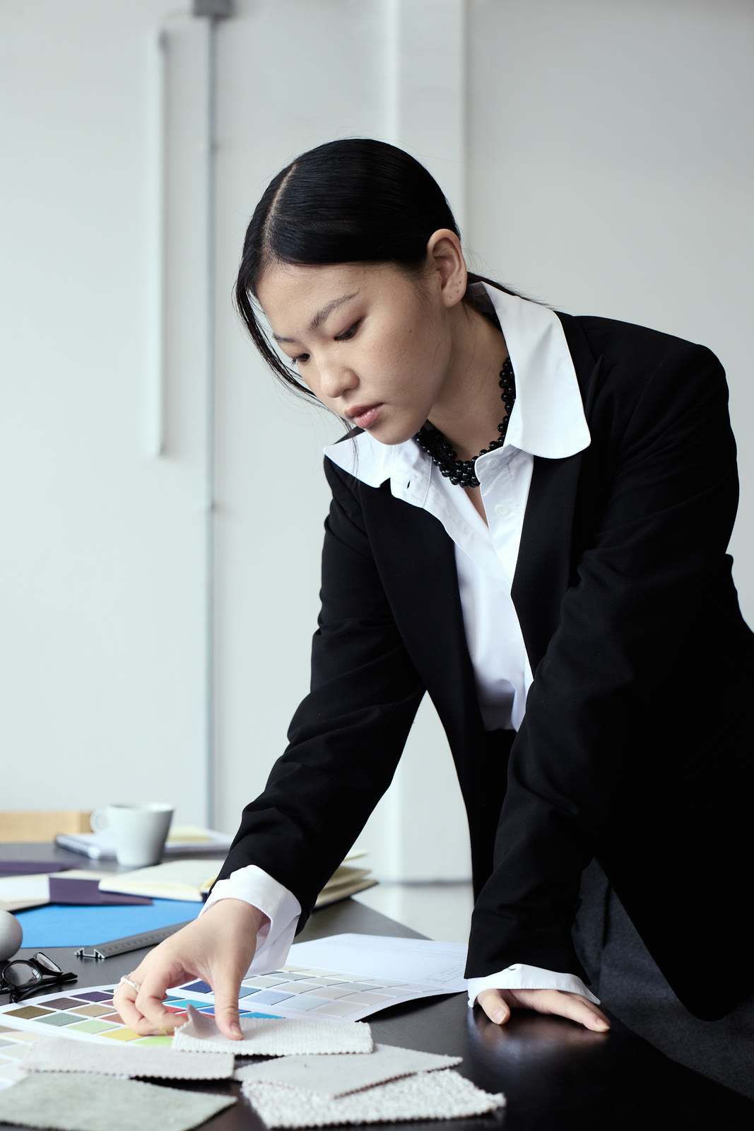 A designer reviewing colour swatches and layouts across a studio desk