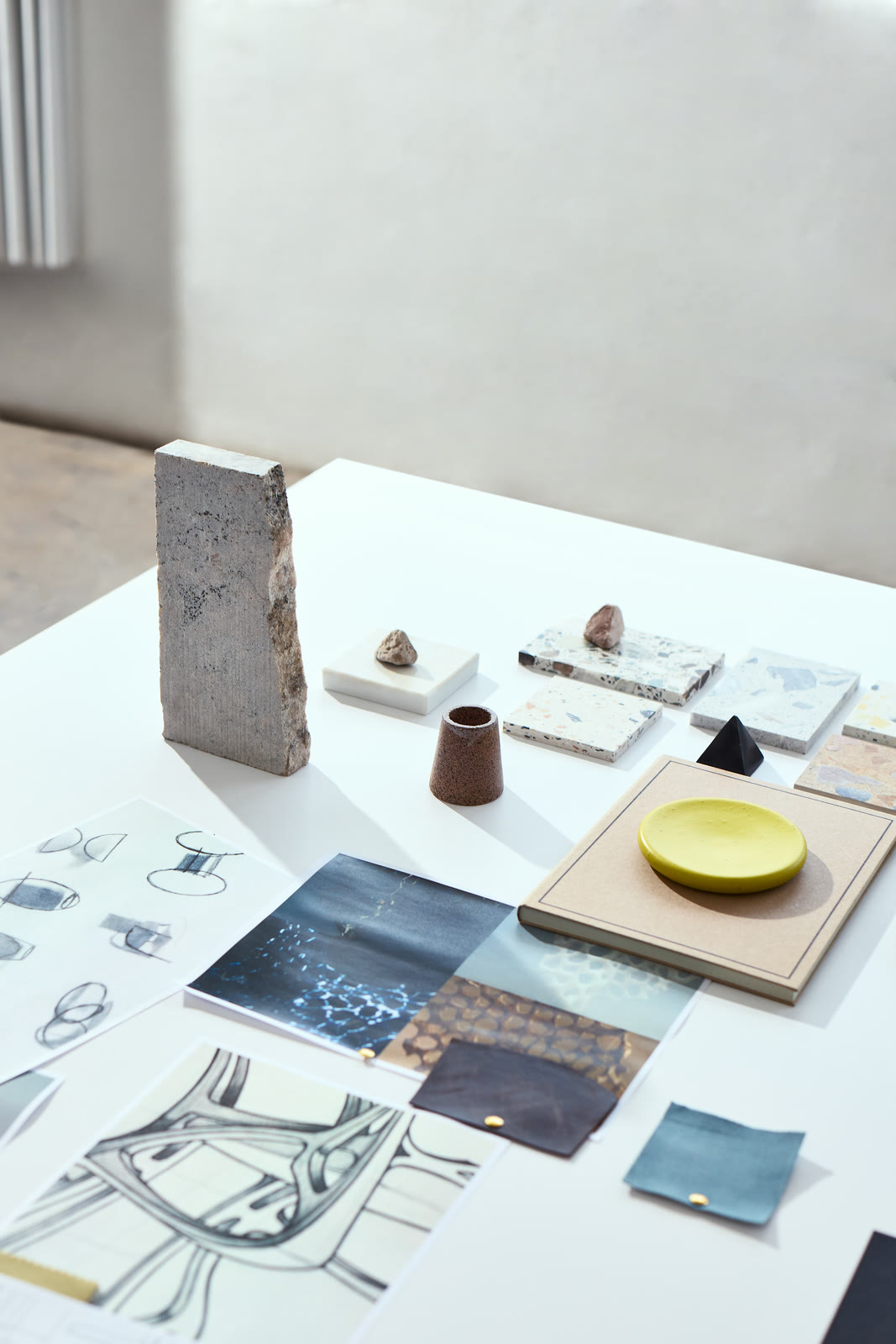 Material samples and colour swatches laid out across a studio table