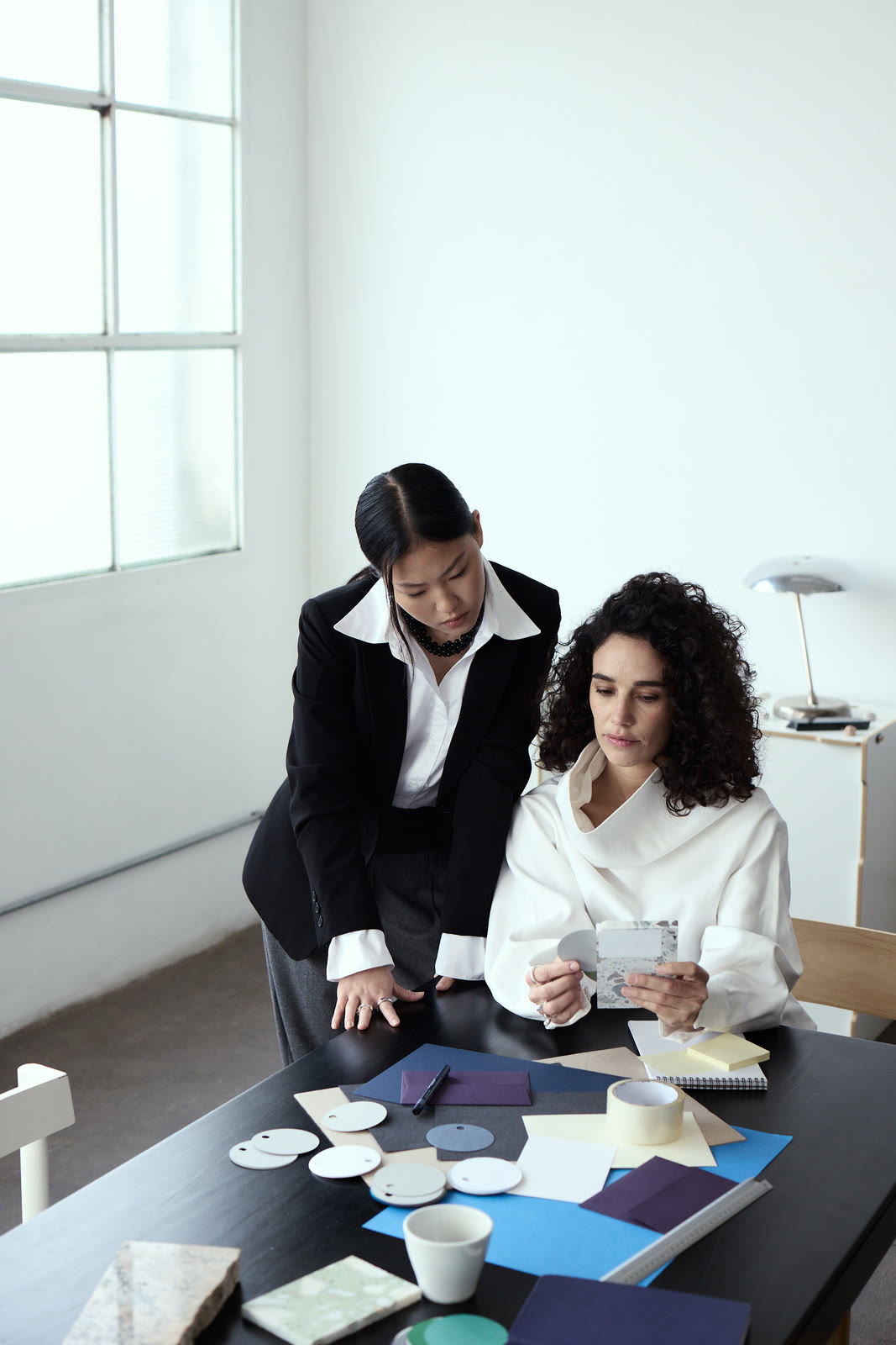 Two colleagues collaborating over samples at a studio desk